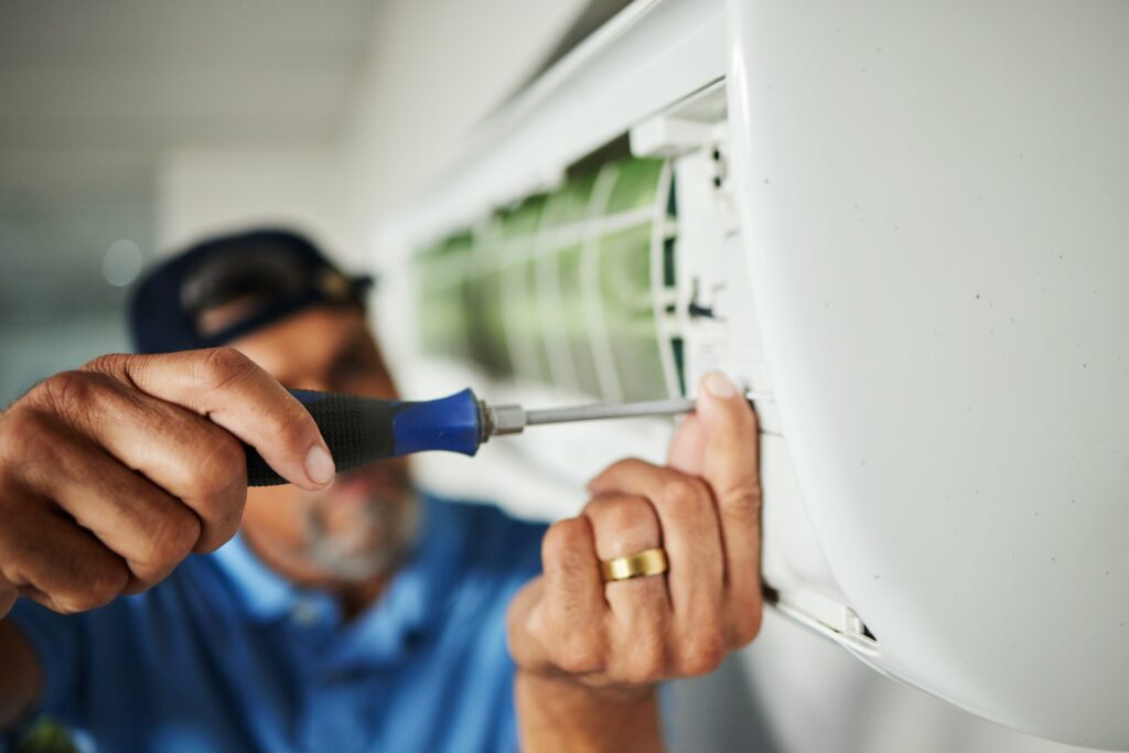 Electrician, hands and air conditioning with man and screwdriver for maintenance, ventilation or po