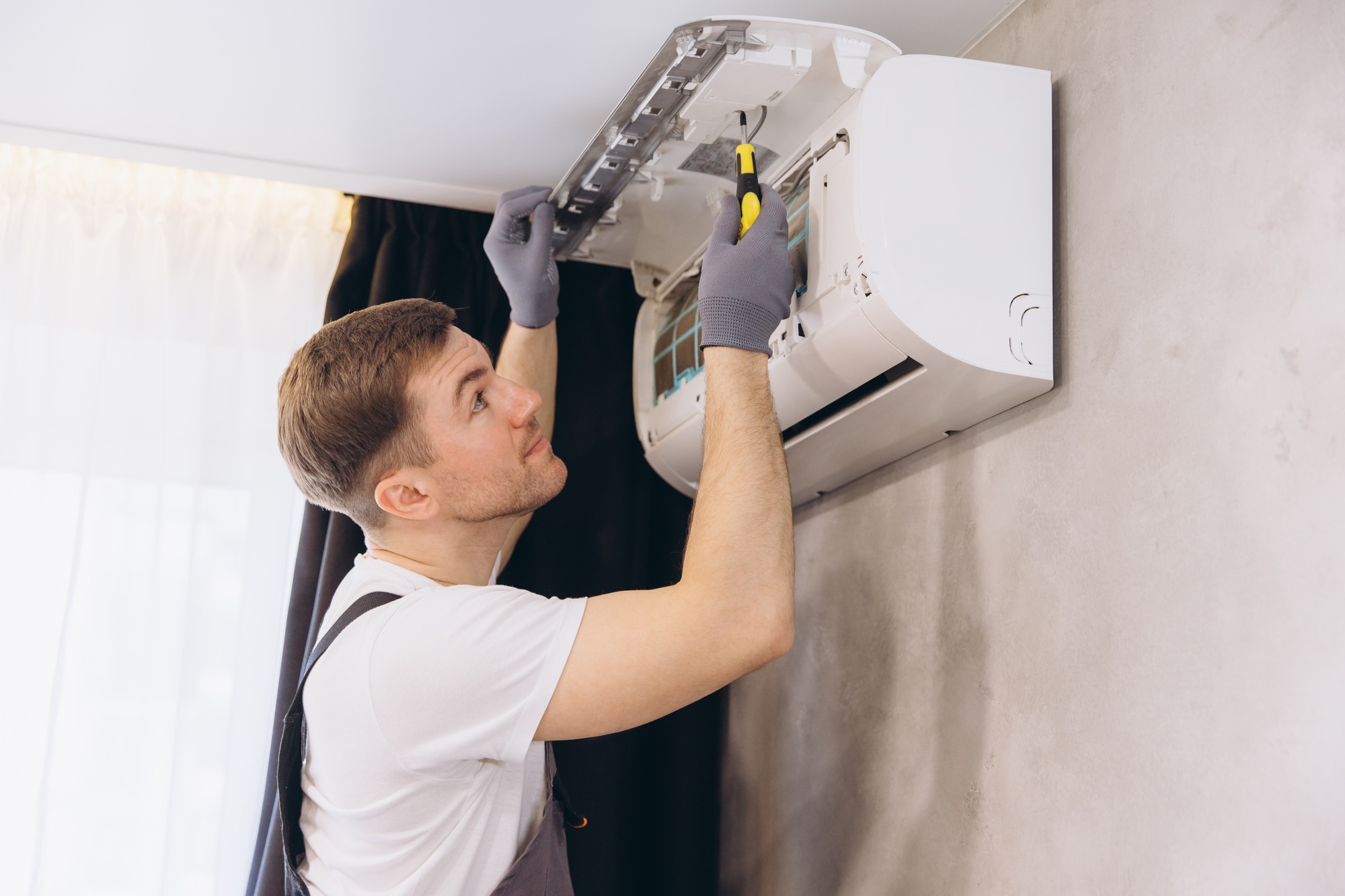 Professional plumber repairing modern air conditioner unit
